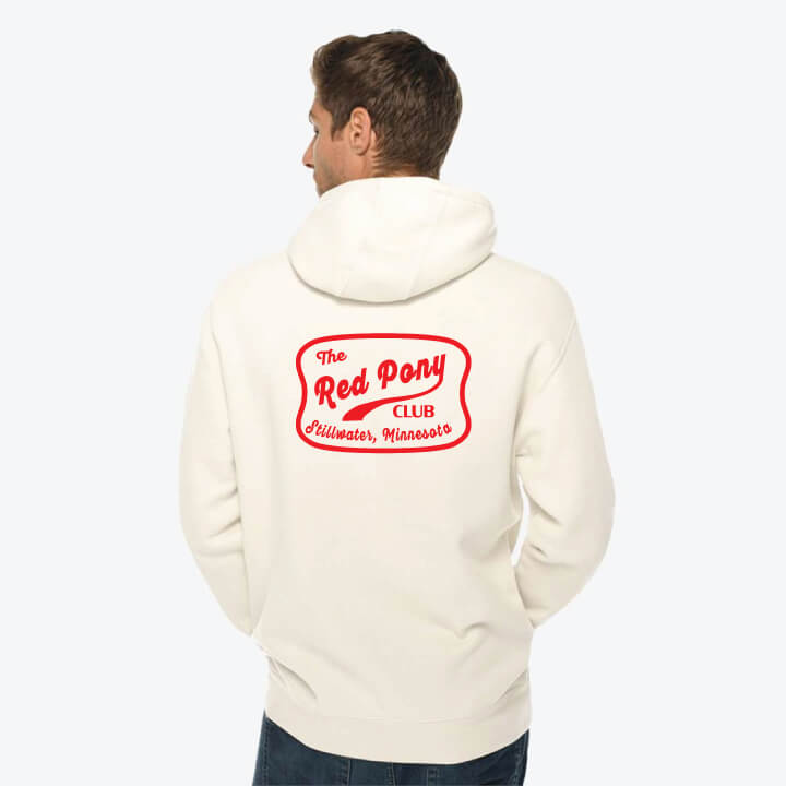 Person wearing a cream hoodie with 'Red Pony Club' logo on the back against a white background