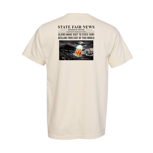A cream-colored short-sleeve t-shirt shown from the back, featuring a graphic print styled like a newspaper headline that reads 'STATE FAIR NEWS' with a black-and-white photo of a fairground and a an alien spaceship sampling french fries.