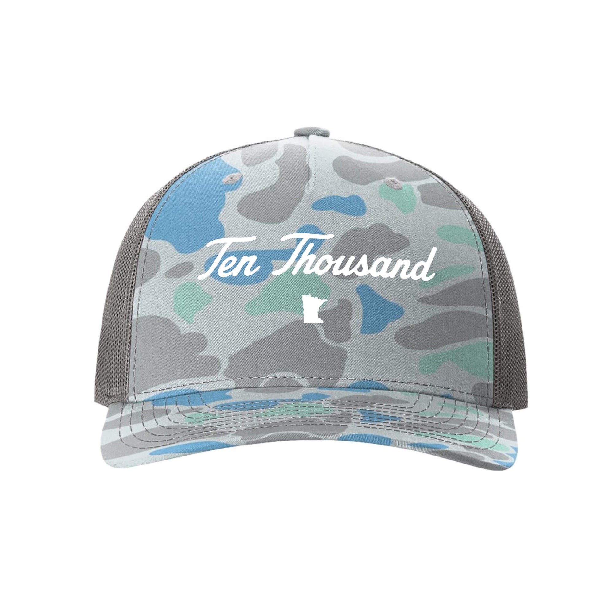 A trucker-style baseball cap with a gray, blue, and mint green camouflage pattern on the front panel and brim, featuring a white script logo that reads 'Ten Thousand' and a small white state outline on the mesh back.